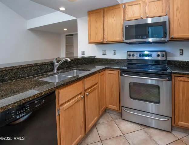 a kitchen with granite countertop a sink a stove and microwave