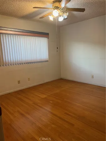 en empty room with wooden floor and windows