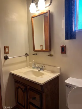 a bathroom with a sink toilet and mirror