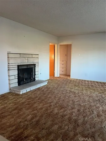 a view of empty room with window and fireplace
