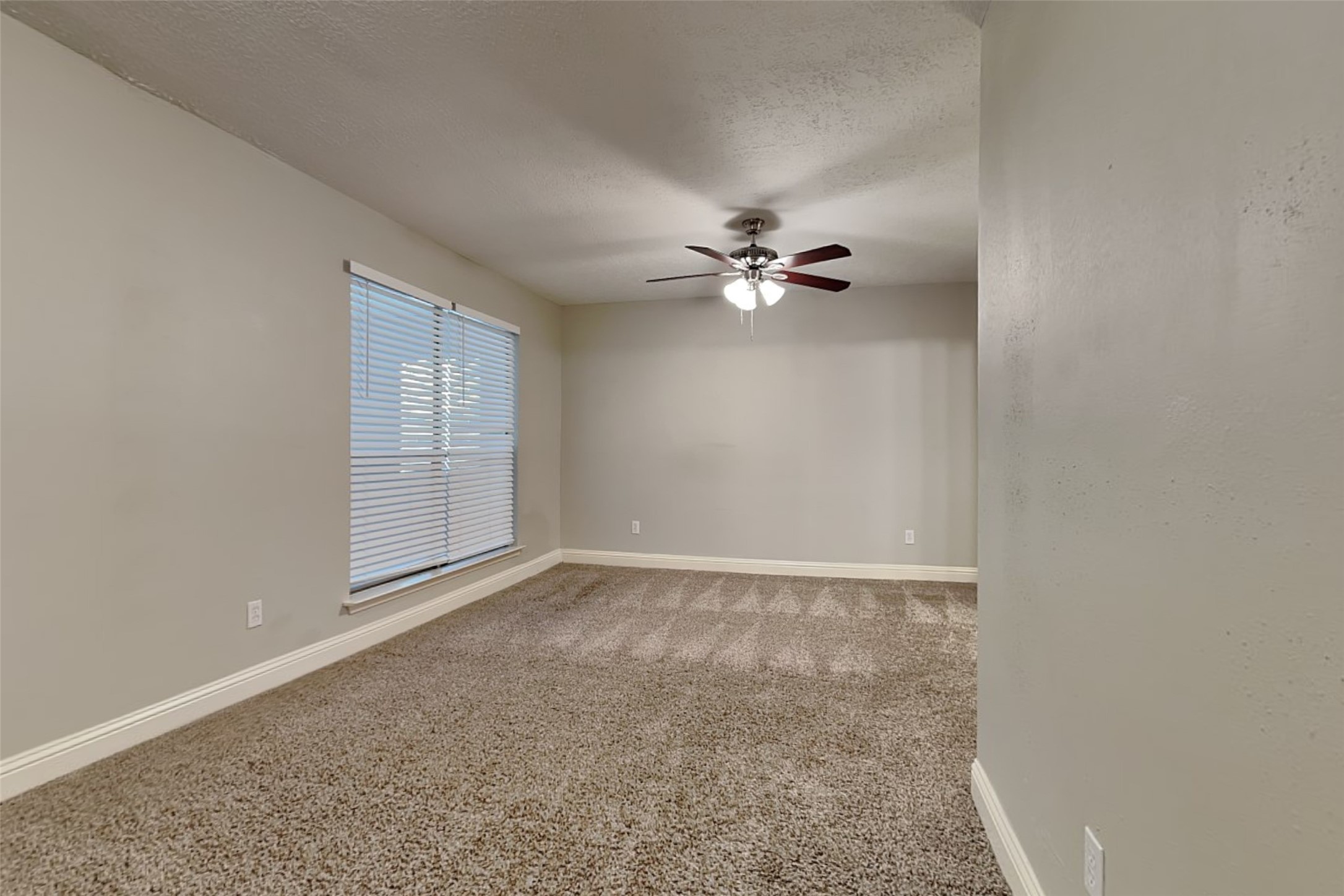 19902 Pinefield Court Humble, TX 77338 - Photo 11 of 23 an empty room with windows and chandelier fan