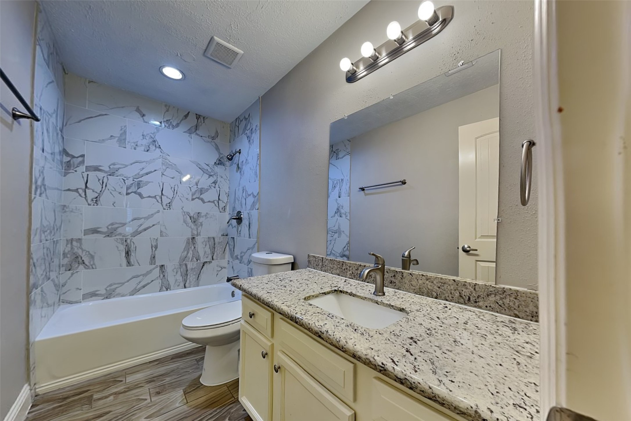 19902 Pinefield Court Humble, TX 77338 - Photo 18 of 23 a bathroom with a granite countertop sink a toilet a mirror and bathtub