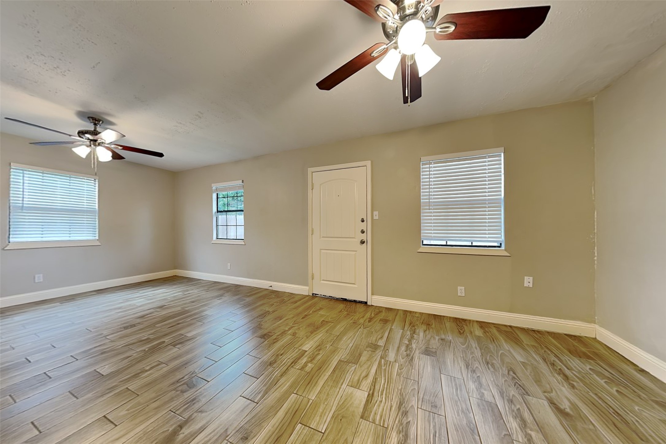 19902 Pinefield Court Humble, TX 77338 - Photo 20 of 23 an empty room with wooden floor chandelier fan and windows