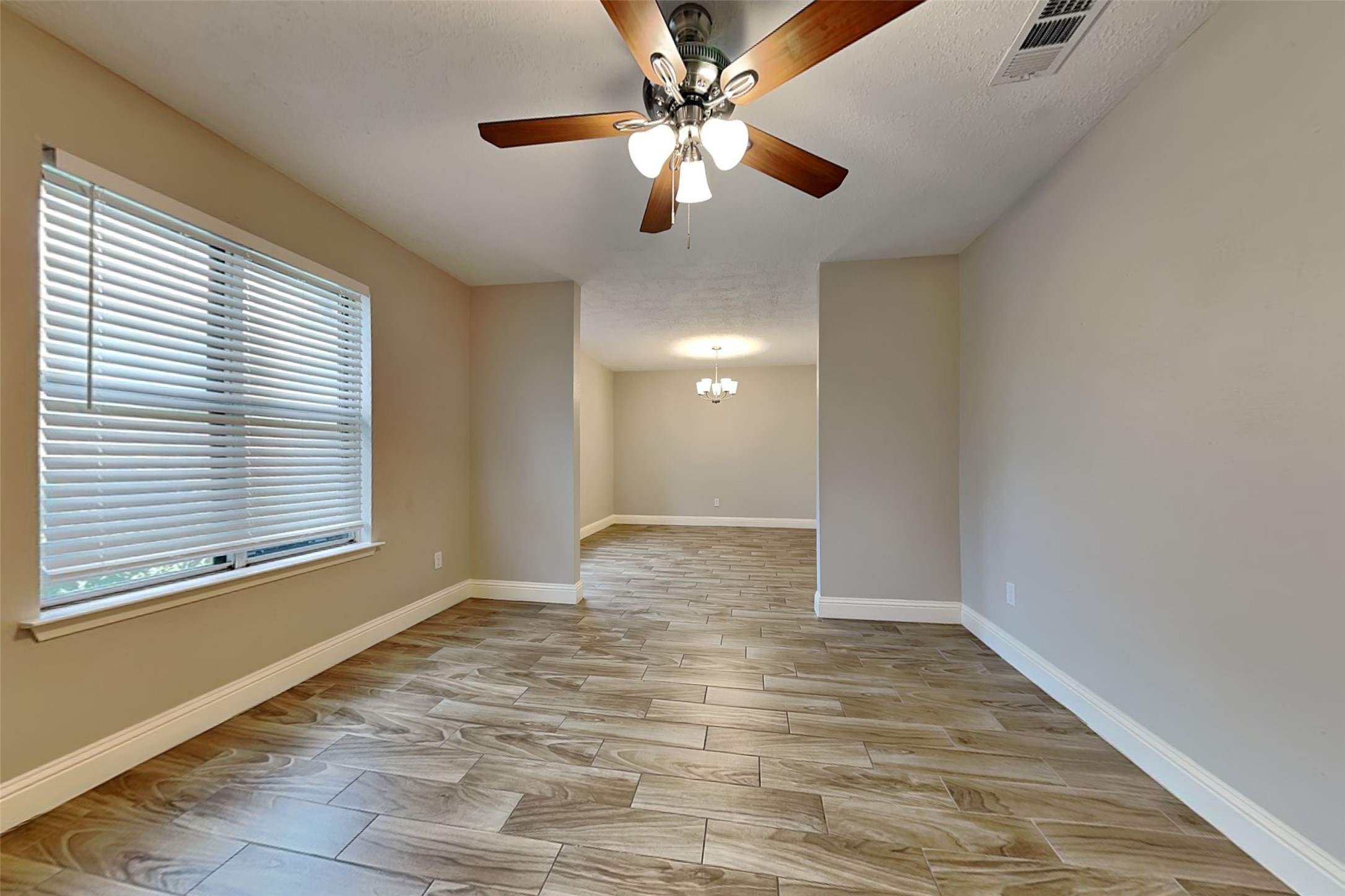 19902 Pinefield Court Humble, TX 77338 - Photo 6 of 23 a view of an empty room with window and chandelier fan