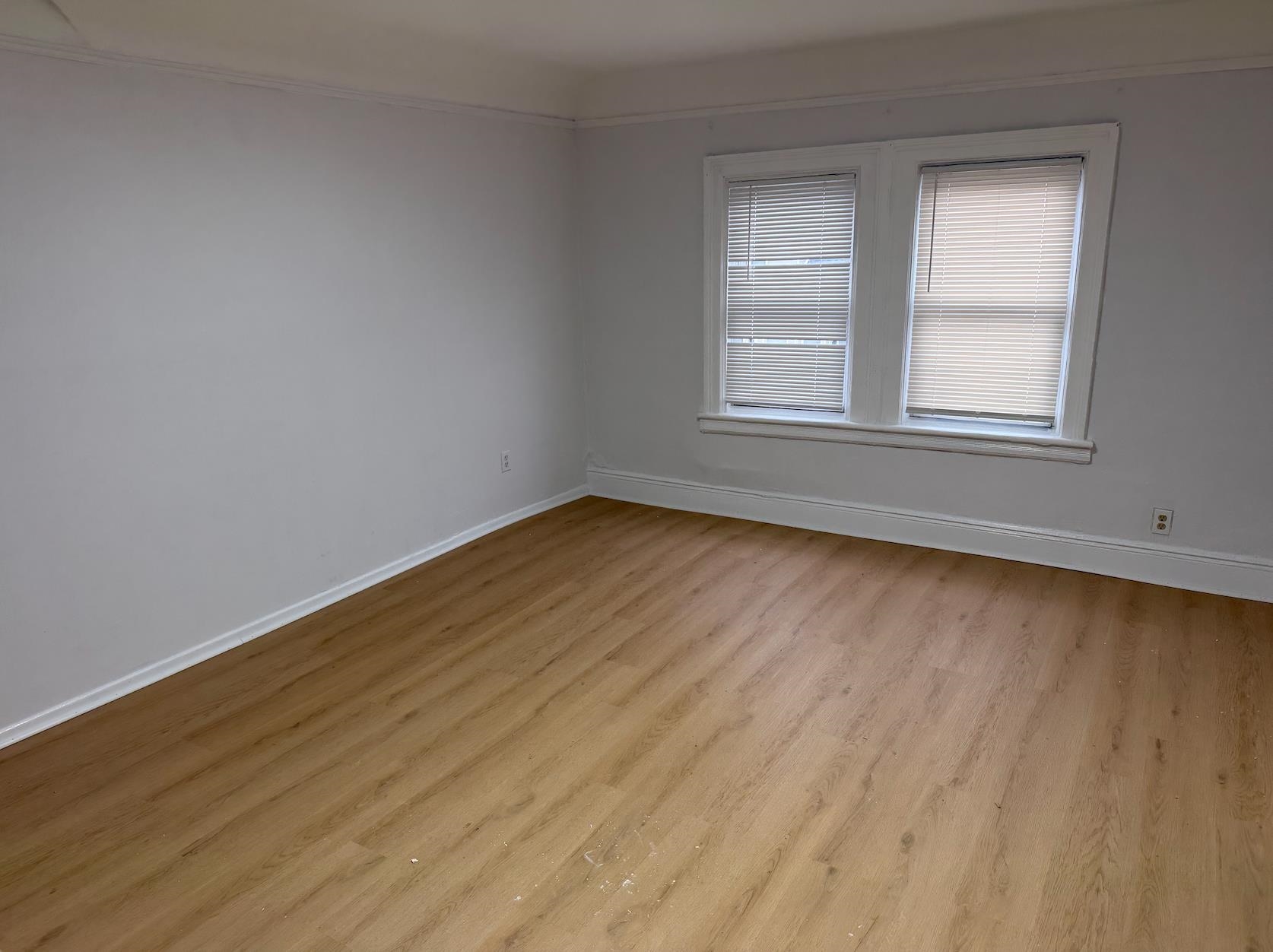 21 49th Street, Unit 3 Weehawken, NJ 07086 - Photo 3 of 5 a view of an empty room with wooden floor and a window