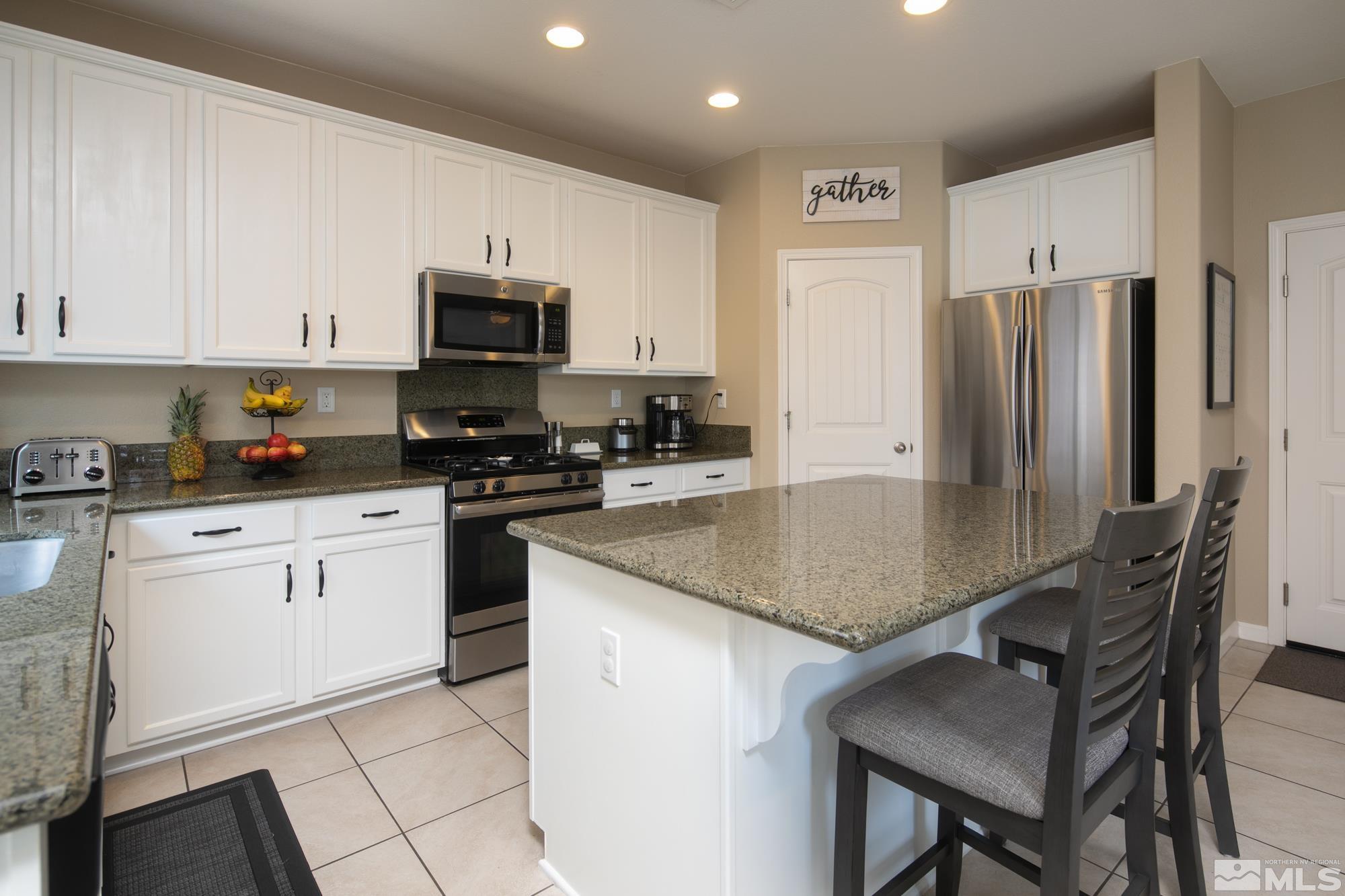 2225 Hope Valley Drive Reno, NV 89521 - Photo 9 of 31 a kitchen with stainless steel appliances granite countertop a stove a refrigerator a sink a dining table and chairs