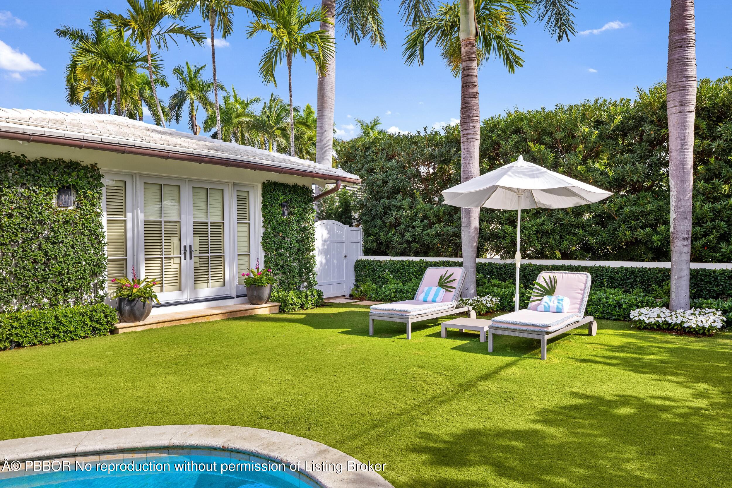 258 List Road Palm Beach, FL 33480 - Photo 42 of 45 a view of a chair and tables in the backyard of the house