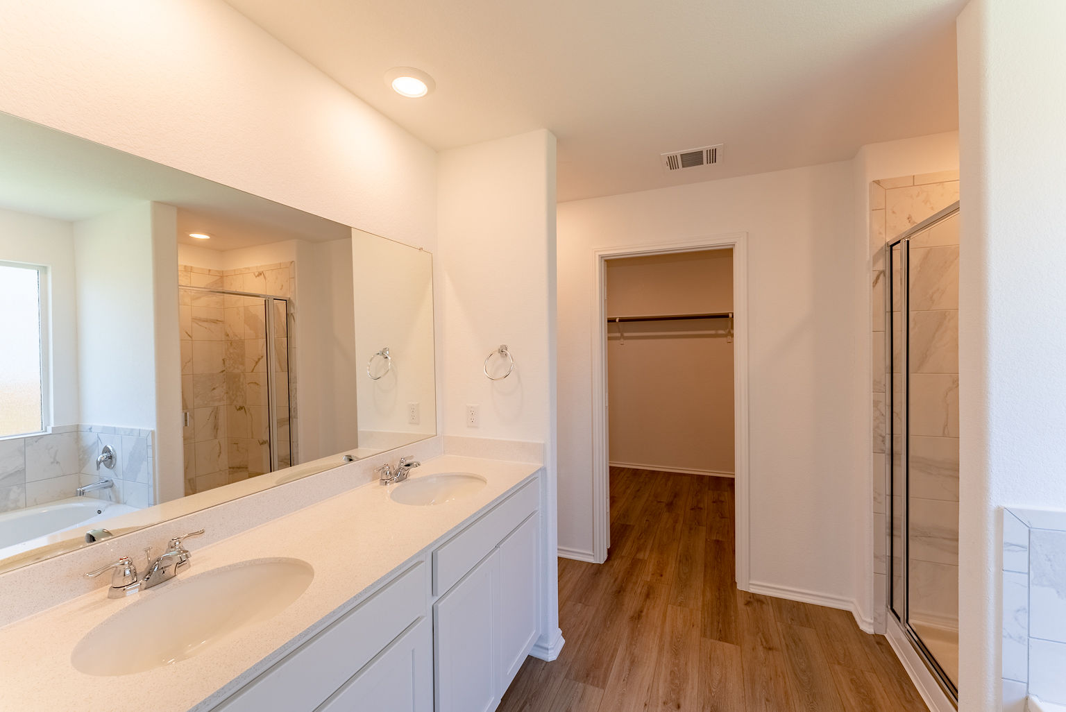 137 River Rise Road Kyle, TX 78640 - Photo 12 of 26 Bathroom featuring a garden tub, a shower stall, a spacious closet, double vanity, and light wood finished floors