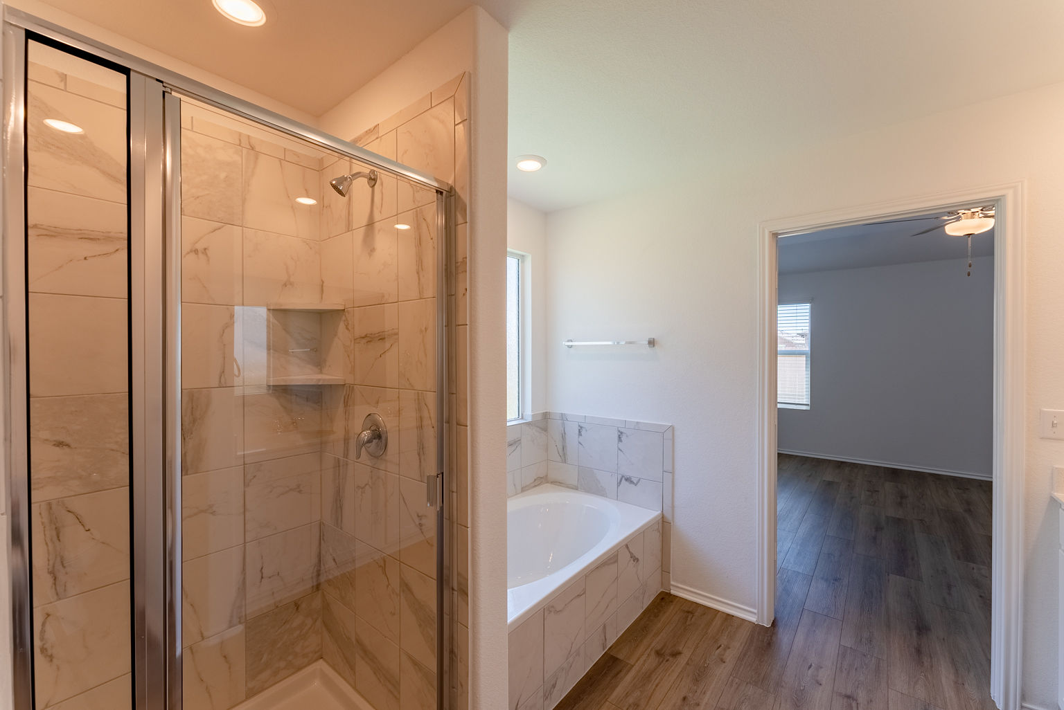 137 River Rise Road Kyle, TX 78640 - Photo 13 of 26 Full bath featuring wood finished floors, a marble finish shower, a garden tub, and recessed lighting