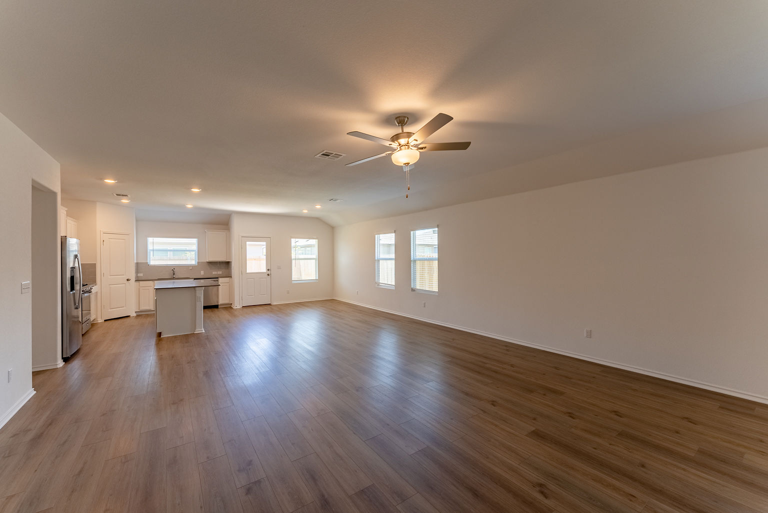 137 River Rise Road Kyle, TX 78640 - Photo 5 of 26 Unfurnished living room featuring dark wood-style flooring, a ceiling fan, recessed lighting, and lofted ceiling