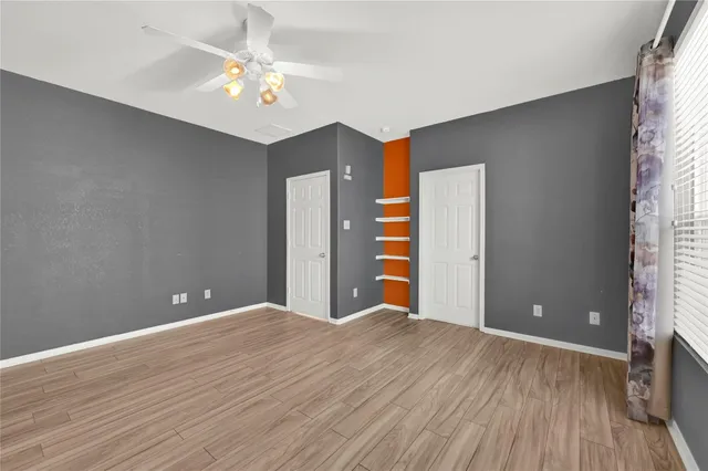 a view of an empty room with wooden floor