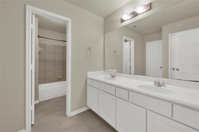 a bathroom with a double vanity sink and a mirror