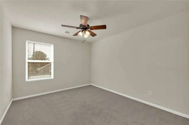 an empty room with a window and a fan