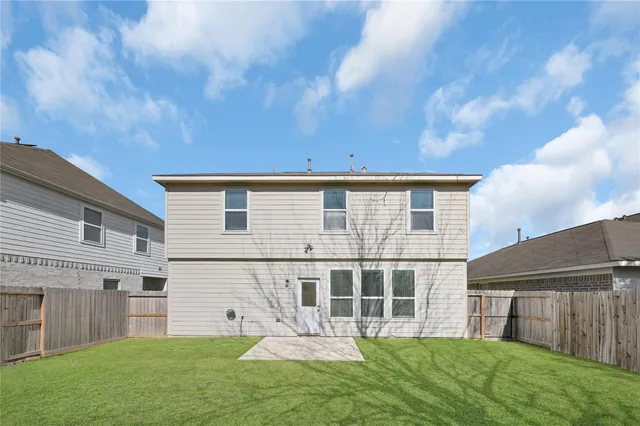 a view of a house with a yard and a large tree