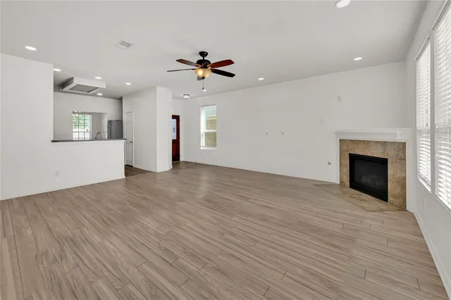 a view of empty room with wooden floor and fireplace