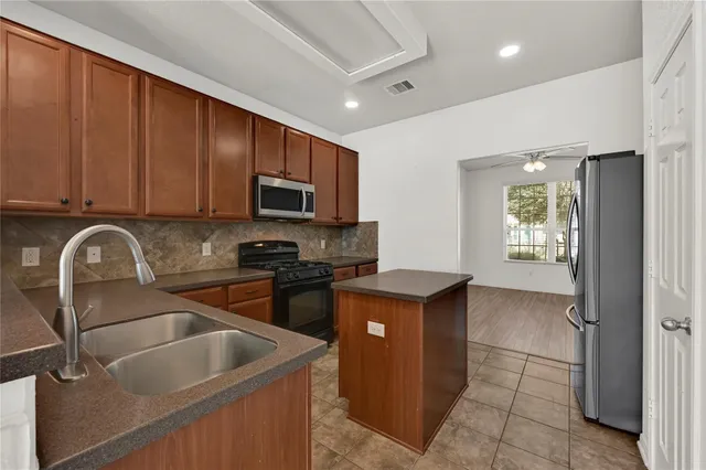 a kitchen with stainless steel appliances granite countertop a sink stove and refrigerator