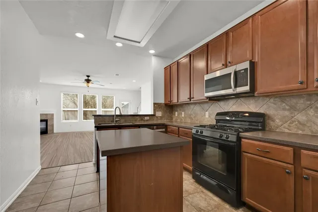 a kitchen with stainless steel appliances granite countertop a stove microwave and cabinets