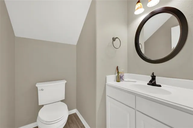 a bathroom with a toilet a sink and a mirror