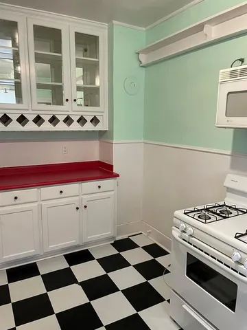 a kitchen with a stove a sink and a cabinets
