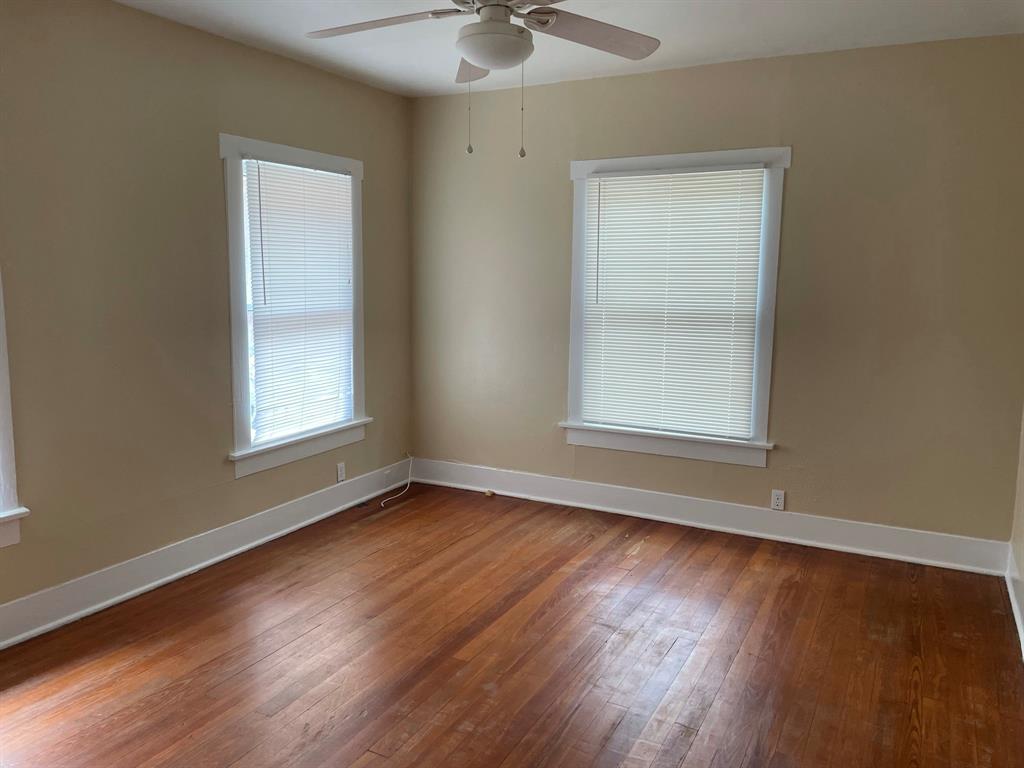 2257 College Avenue Fort Worth, TX 76110 - Photo 7 of 26 a view of an empty room with wooden floor and a window