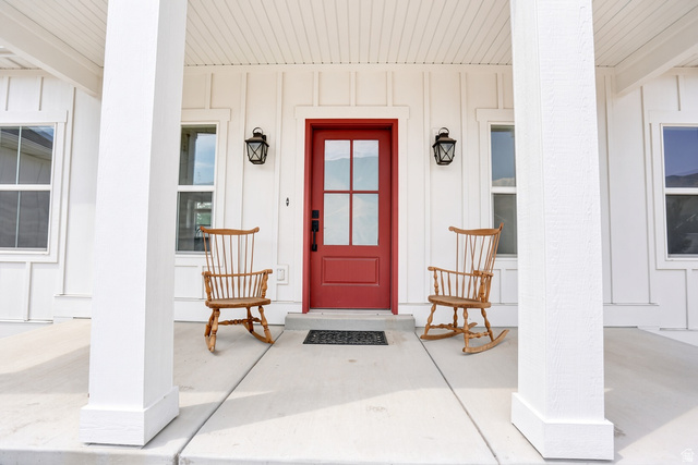 1257 North 1350th Street East Mapleton, UT 84664 - Photo 2 of 34 White board-and-batten siding with a red paneled entry door
