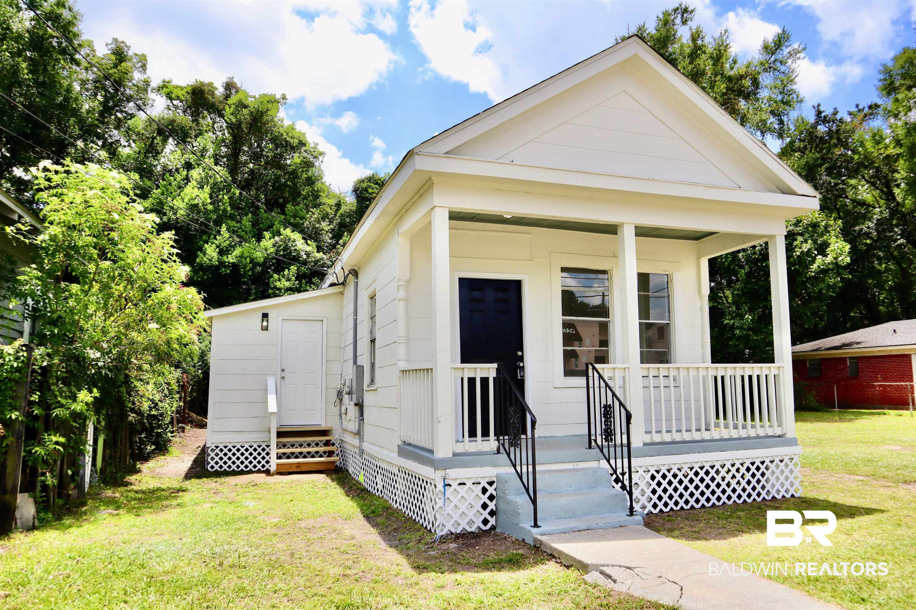 1009 Baltimore Street Mobile, AL 36605 - Photo 2 of 17 Shotgun-style home featuring covered porch and a front lawn