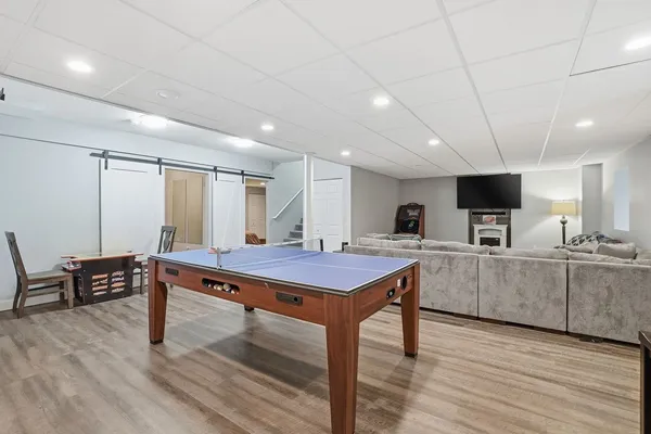 a bedroom with a bed a couch and wooden floor