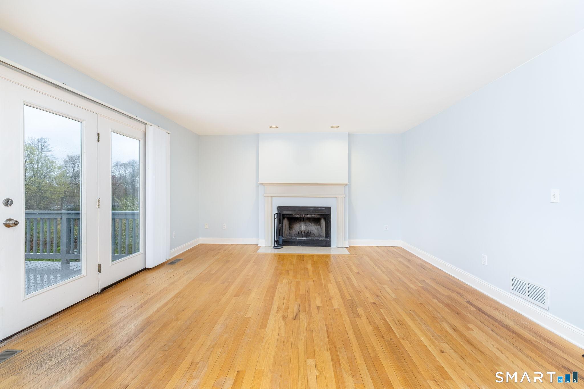 1057 Daniels Farm Road Trumbull, CT 06611 - Photo 14 of 40 a view of a livingroom with a fireplace wooden floor and windows