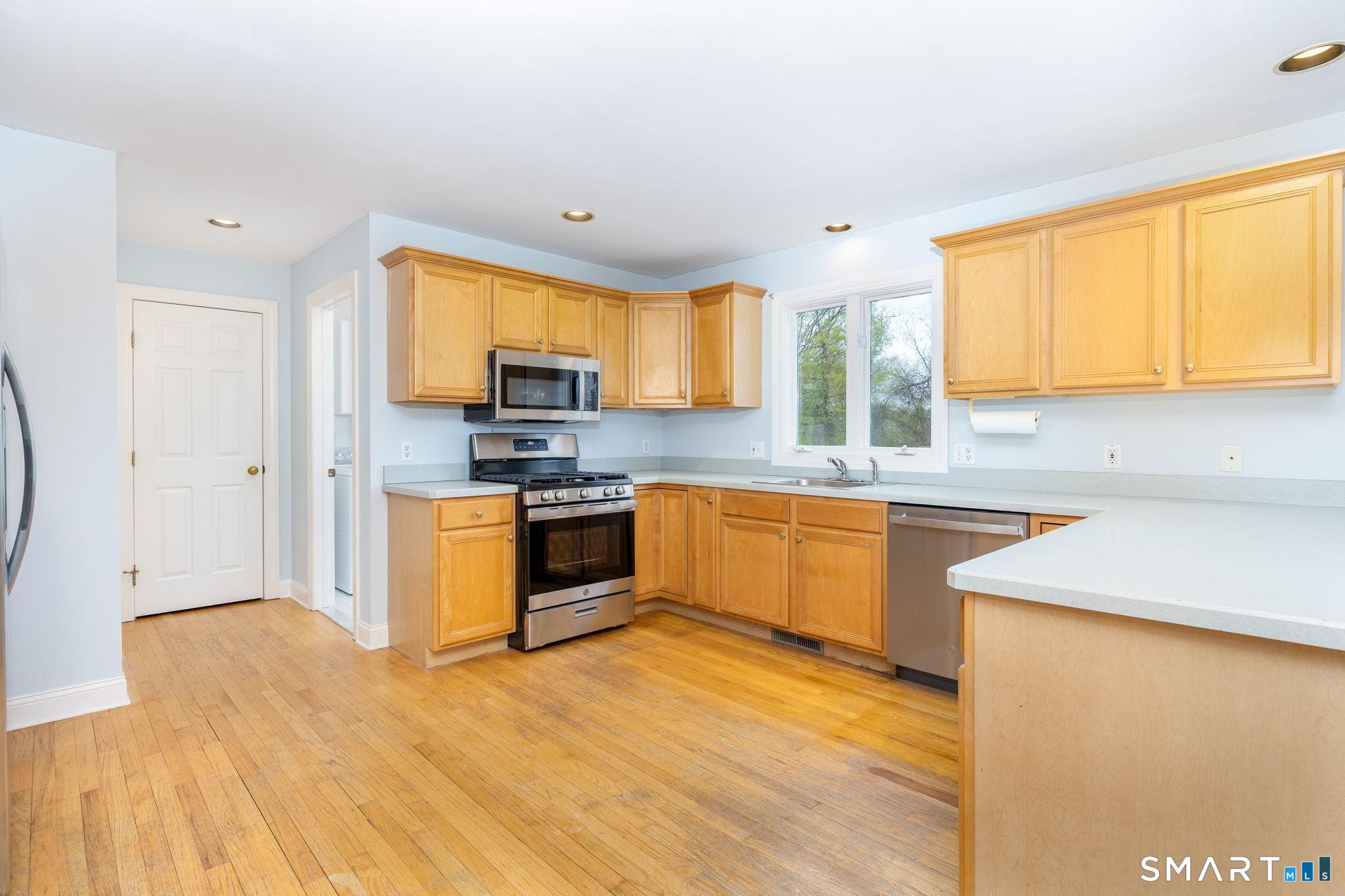 1057 Daniels Farm Road Trumbull, CT 06611 - Photo 18 of 40 a kitchen with stainless steel appliances granite countertop a sink a stove a refrigerator with grey cabinets