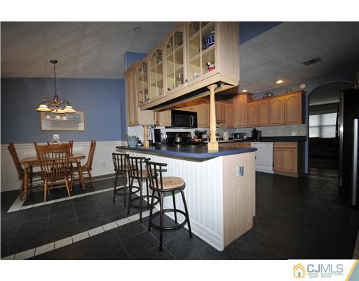 33 Sturgis Road Edison, NJ 08817 - Photo 10 of 10 a kitchen with stainless steel appliances granite countertop a stove top oven a dining table and chairs
