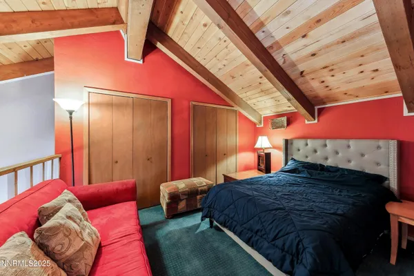 a large bedroom with a bed next to a window