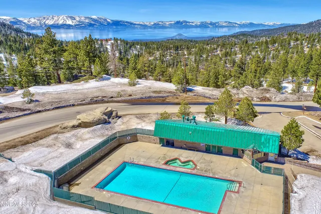 a view of a pool with a table and chairs under an umbrella