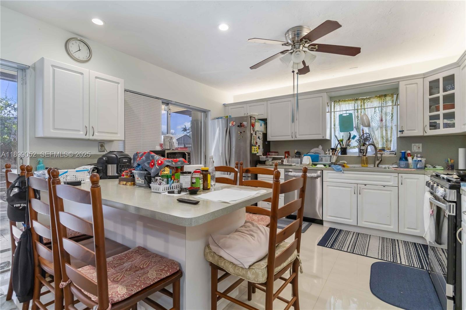 12410 Southwest 106th Terrace Miami, FL 33186 - Photo 11 of 27 a kitchen with a dining table chairs and white cabinets