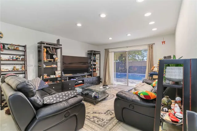 a view of a dining room and livingroom with furniture wooden floor a chandelier