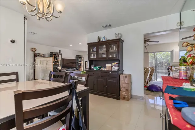 a kitchen with a dining table chairs and white cabinets