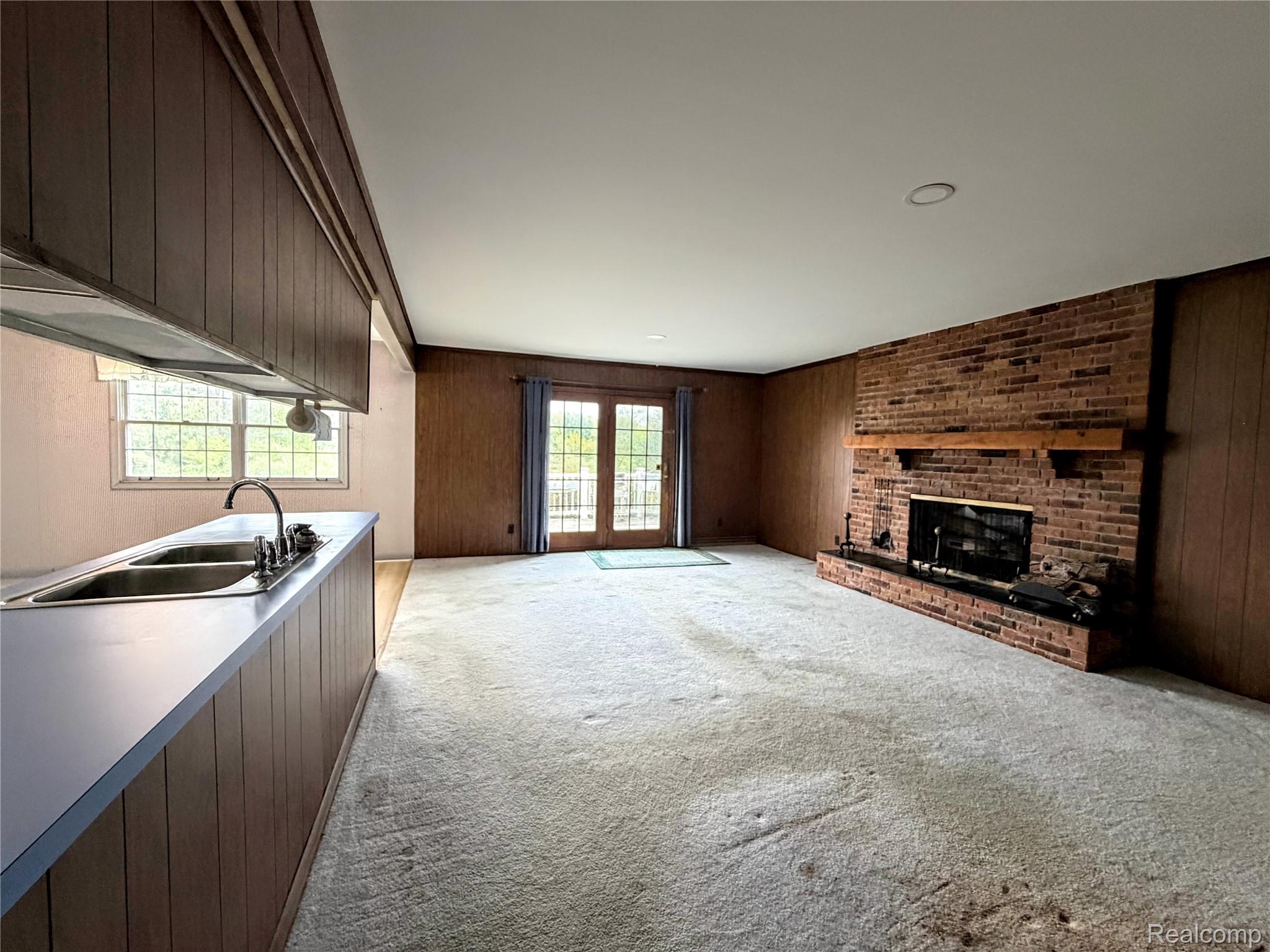 8079 Farley Road Pinckney, MI 48169 - Photo 13 of 43 Featuring wood walls, light carpet, and a fireplace