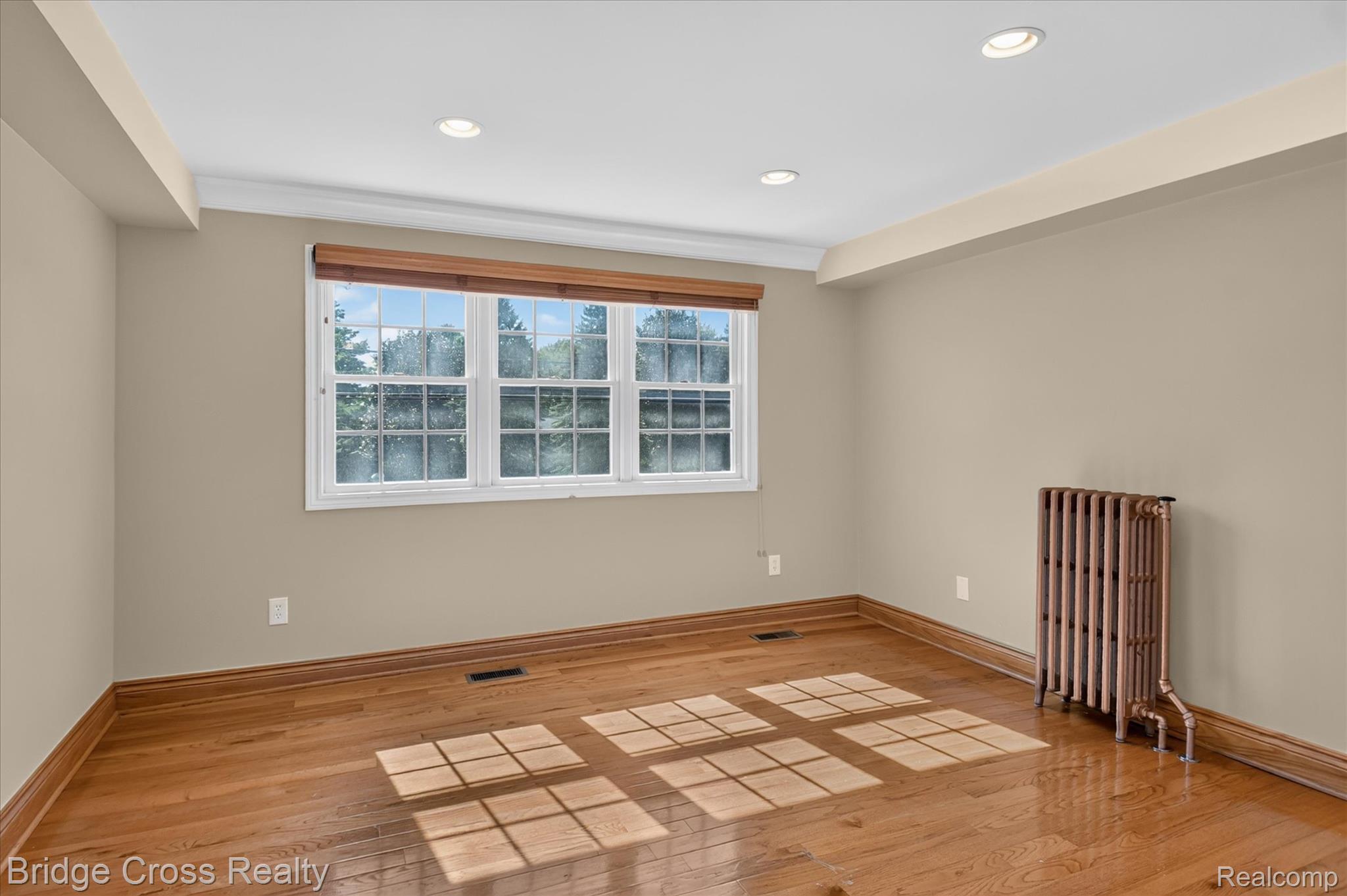 285 East Long Lake Road Troy, MI 48085 - Photo 21 of 49 Hardwood flooring, recessed lighting, white trim molding, classic-style window, and a vintage radiator