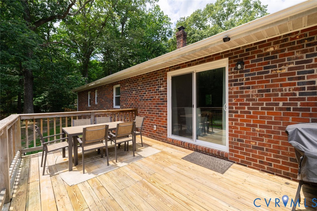 12397 New Market Mill Road Beaverdam, VA 23015 - Photo 33 of 44 a view of a patio with table and chairs with wooden floor and fence