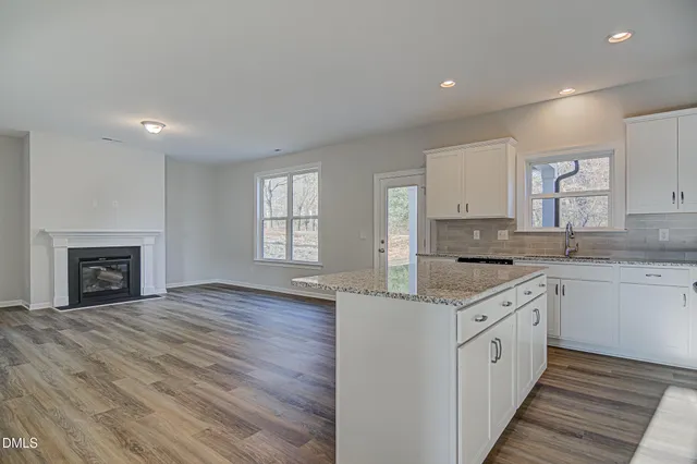 a kitchen with granite countertop a stove top oven sink and cabinets
