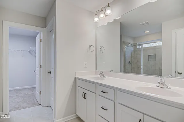 a bathroom with double vanity sink and a mirror