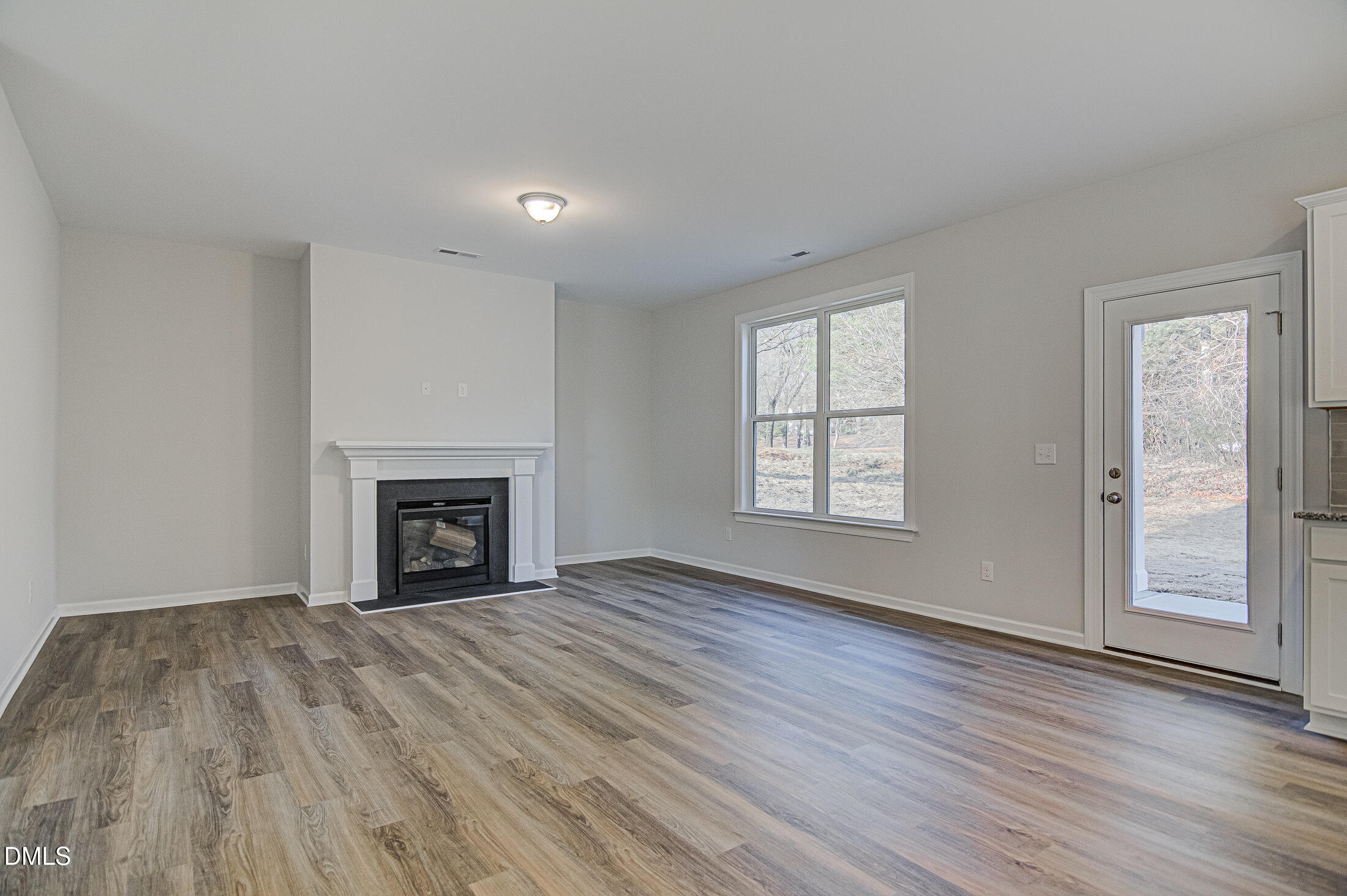 108 Starlet Ridge Way Clayton, NC 27520 - Photo 4 of 37 a view of an empty room with wooden floor fireplace and a window