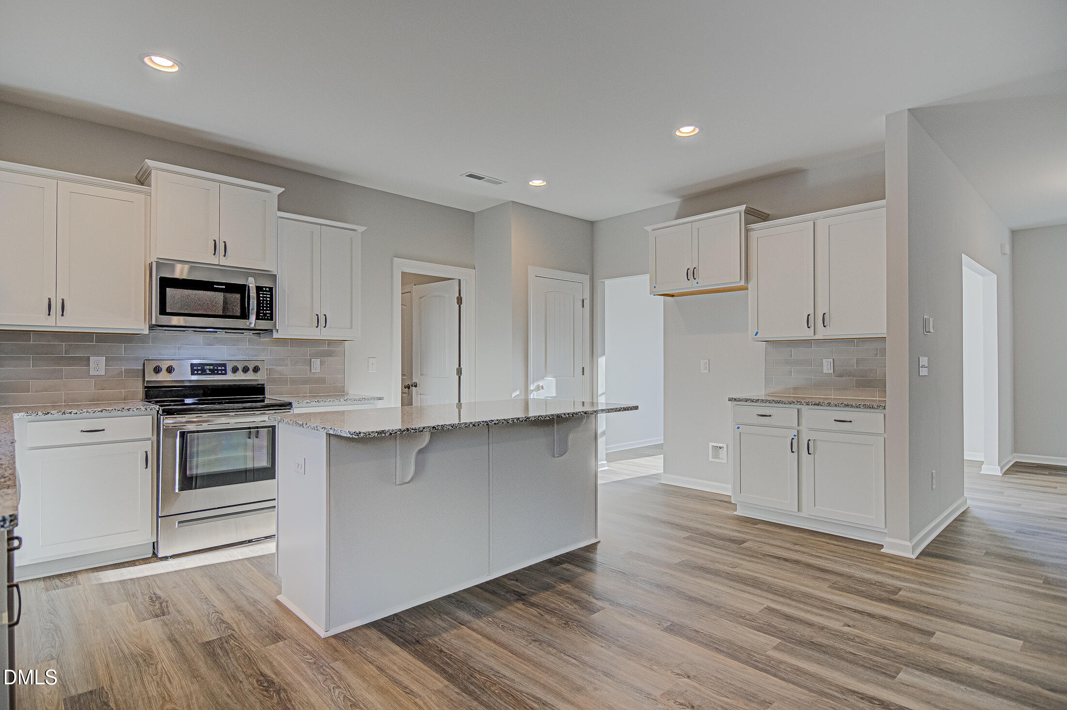 108 Starlet Ridge Way Clayton, NC 27520 - Photo 10 of 37 a kitchen with granite countertop white cabinets and stainless steel appliances