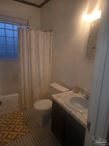 a bathroom with a granite countertop sink toilet and a mirror