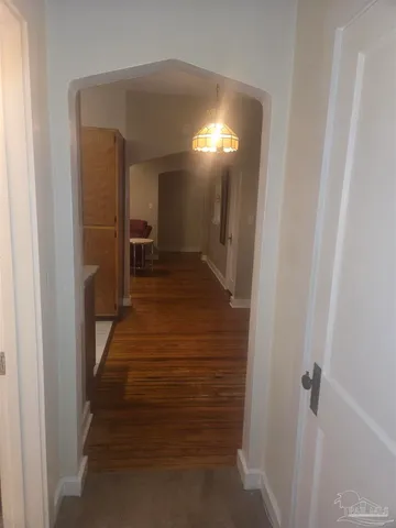 a view of a hallway with wooden floor and closet
