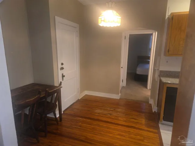 a view of a hallway and wooden floor with a sink