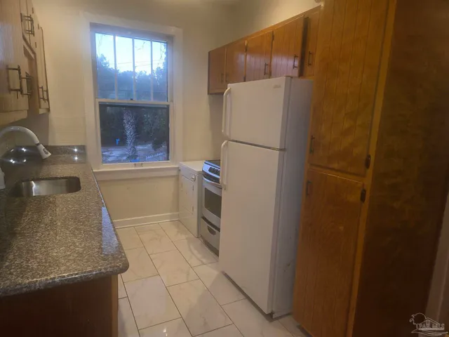 a white refrigerator freezer and a stove sitting inside of a kitchen