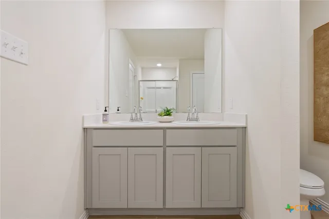 a bathroom with a sink vanity and a toilet