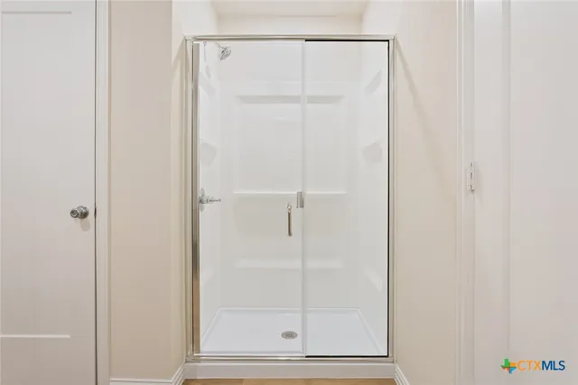 a bathroom with a glass shower door