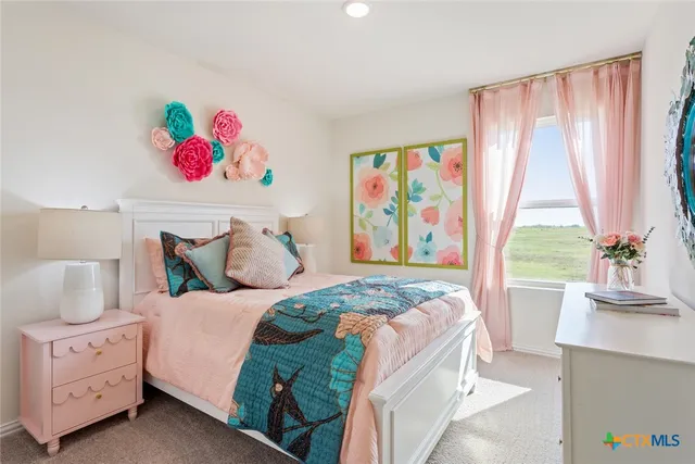 a bedroom with a bed a dresser and a window