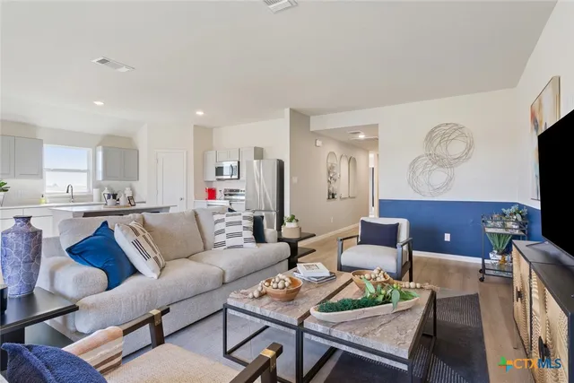 a living room with furniture kitchen view and a dining table